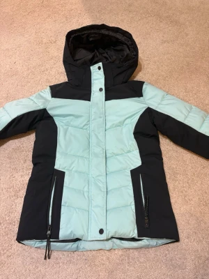 Svart och turkos pufferjacka McKinley - Säljer en vindjacka från McKinley i svart och turkos i strl 164, eller en XS! 