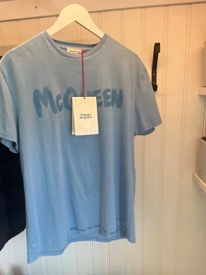 Alexander McQueen T-shirt - Säljer denna Alexander McQueen T-shirt pågrund av att den inte kommer till användning. Använd endast en gång så i princip helt ny. Nypris ca 3000 kr. Storlek M men sitter större. Hör av dig om du har några frågor! 