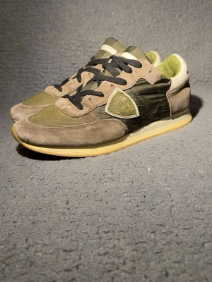 Philippe Model grå sneakers med mocka - Säljer ett par stilrena och lyxiga sneakers från Philippe Model i grön/grå ton med mocka- och textildetaljer. Ett märke känt för hög kvalitet, komfort och tidlös design – perfekta både till vardag och mer uppklädda outfits. 👣 Storlek: 40 (passar även dig som vanligtvis har 41) 💰 Nypris: ca 3000 kr (köpta för 2000 kr) 💸 Mitt pris: 1299 kr – kan diskuteras vid snabb och smidig affär Skorna är sparsamt använda och i fint skick. Väldigt bekväma och ger en exklusiv look utan att sticka ut för mycket.