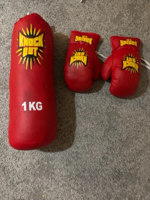 Boxningssäck och boxningshandskar - Rött boxningsset med boxningshandskar och en boxningssäck.  köpt på leksaksaffären . Finns säck till . 
