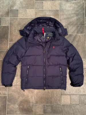 Mörkblå dunjacka från Polo Ralph Lauren - Eftertraktad mörkblå jacka ifrån Ralph lauren🐎Nyskick ✅ Tillbehör finns kvar🔖 Kontakta mig vid eventuella frågor 📞