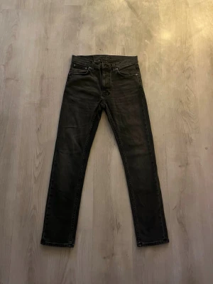 Svarta jeans från Nudie Jeans - Säljer ett par svarta jeans från Nudie Jeans. Jeansen har rak passform och är tillverkade i slitstarkt denimtyg. Perfekt för dig som gillar stilrena och tidlösa jeans. Jeansen är använda få gånger!