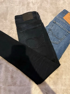 Jack & Jones jeans, mörk blå och blå - Säljer 2 par riktigt feta jack & jones jeans, en är mörk blå och är i storlek 30 32 och dem vanliga blå är i storlek 28 32. Båda är i modelen slim glenn och dem är i jätte bra skick.