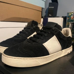 Valentino svartvita Rockrunner sneakers - Svarta och vita Valentino flycrews sneakers i mocka och skinn med klassiska nitar på hälen. Snygg kontrast mellan svart mocka och vit skinnpanel, rund tå och platt sula. Perfekta för dig som vill ha en stilren men edgy look. Om du vill ha fler bilder eller bara vill fråga något är det bara att kontakta!några nitar saknas på skonarna men det går att köpa till nya om man skulle vilja det.