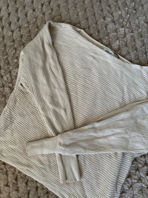 Beige ribbad stickad tröja från ONLY - Säljer en beige långärmad stickad tröja från ONLY i storlek M. Tröjan har ett ribbat mönster och rund hals. Perfekt för dig som gillar enkel och stilren design med mjukt material som känns skönt mot huden.