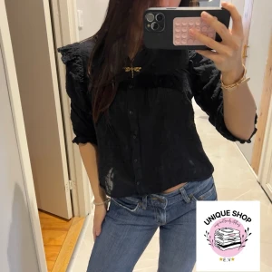 Svart Trekvartsärmad blus  - Svart Trekvartsärmad blus med knappar och volang  !! 