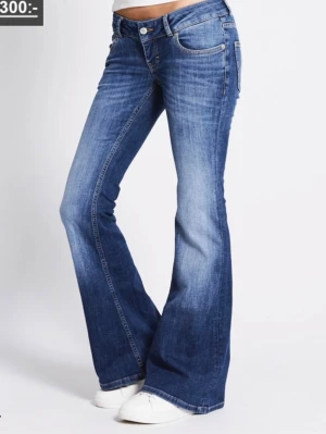 Low rise jeans blaze - Snygga blå jeans med bootcut-snitt och låg midja från lager 157. Jeansen har klassisk femficksdesign, knapp och dragkedja fram samt lätt tvättad look. Materialet är jeans i bomull med lite stretch för skön passform. Perfekta för dig som gillar retrovibbar och vill ha ett statement-plagg.