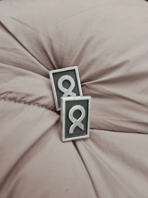 Machettknappar | R.Tennsmed - Machettknappar av formgivaren R.Tennsmed, symbolen är Omega. Passar dig som vill ha en stilren look med extra.. 