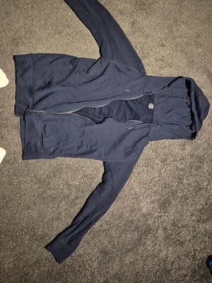 Mörkblå Ziphoodie - On Tour Terms - Snygg mörkblå ziphoodie från On Tour Terms i mycket bra skick. Bra passform, bra kvalitet, hållbart bomull.