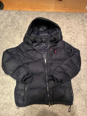 Ralph lauren jacka  - Säljer ni min Ralph lauren jacka i bra men använt skick, hör av er vid frågor! Dragsjedjan är trasig på höger ficka och har lite små håll i jackan