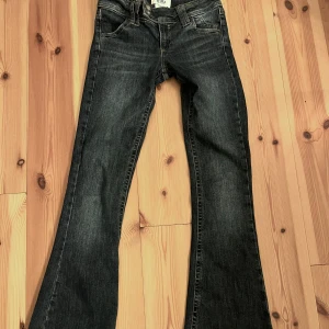 Bootcut jeans från BDG Urban Outfitters - Mörkblå bootcut jeans från BDG Urban Outfitters med klassisk femficksdesign och snygga kontrastsömmar. Jeansen har normal passform och är tillverkade i ett robust denimtyg. Perfekta för dig som gillar en tidlös och avslappnad look.