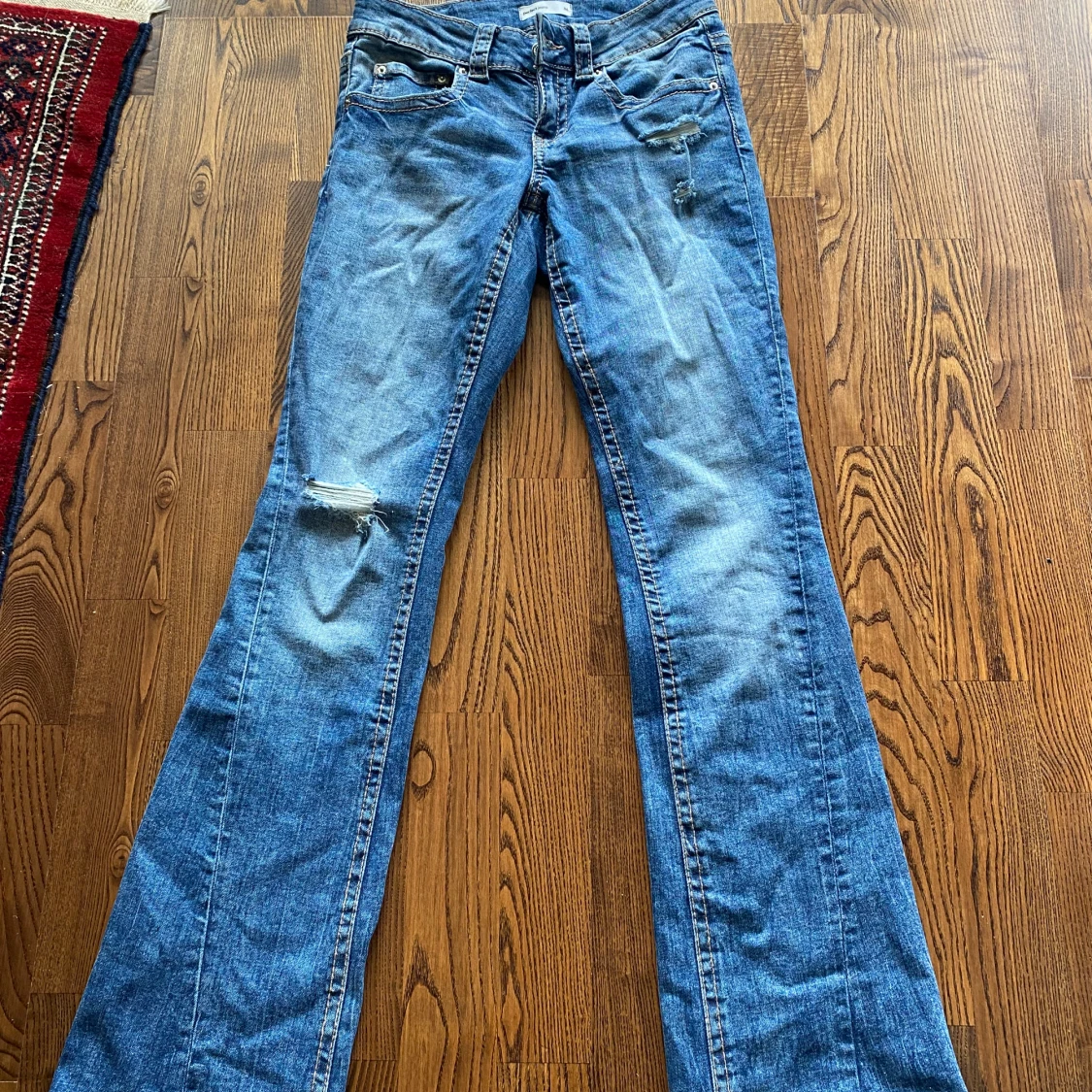 Blå bootcut jeans med slitningar