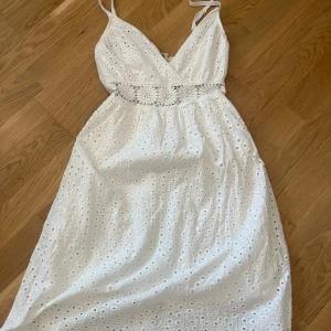 Vit somrig klänning med broderi - Superfin vit klänning med smala axelband, v-ringning och broderade blommor i midjan. Klänningen har hålbroderier över hela tyget och en luftig passform som passar perfekt till varma dagar. Materialet känns lätt och svalt. Skriv för fler bilde🥰