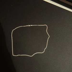 Tunt silverarmband i kedjemodell - Säljer ett stilrent och smalt armband i silverfärgad kedja med klassiskt lås. Perfekt för dig som gillar minimalistiska smycken och vill ha något som funkar till allt. Enkel design som passar både ensam eller i kombination med andra armband. Inga större repor, bra skick och låsen funkar toppen!