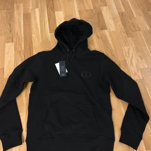 Svart hoodie från Dior med logga - Svart hoodie från Dior med broderad CD-logga på bröstet. pris kan sänkas vid snabb affär 