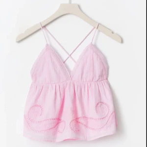 Ljusrosa linnetopp med broderi - Supersöt ljusrosa linnetopp med tunna axelband som korsas i ryggen. Helt ny och endast testad men tog tyvärr av prislappen, original pris 300.💕🩷storek 170 men passar som en xs eller S