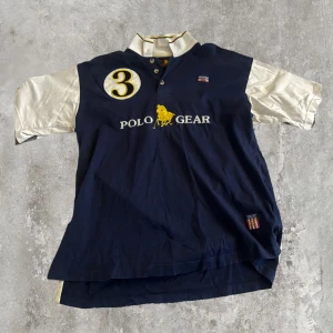 Polo Gear pikétröja blå/vit med tryck - Snygg pikétröja från Polo Gear i marinblått och vitt, strl M men passar allt ifrån S-L, skriv privat för fler frågor 