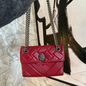 Röd quiltad axelväska från Kurt Geiger - Säljer en snygg röd axelväska från Kurt Geiger med quiltad design och kedjeaxelrem. Använd men bra skick . obs! inte mina bilder men om ni vill ha mer bilder skriv privat. kan även tänka mig gå ner i pris.