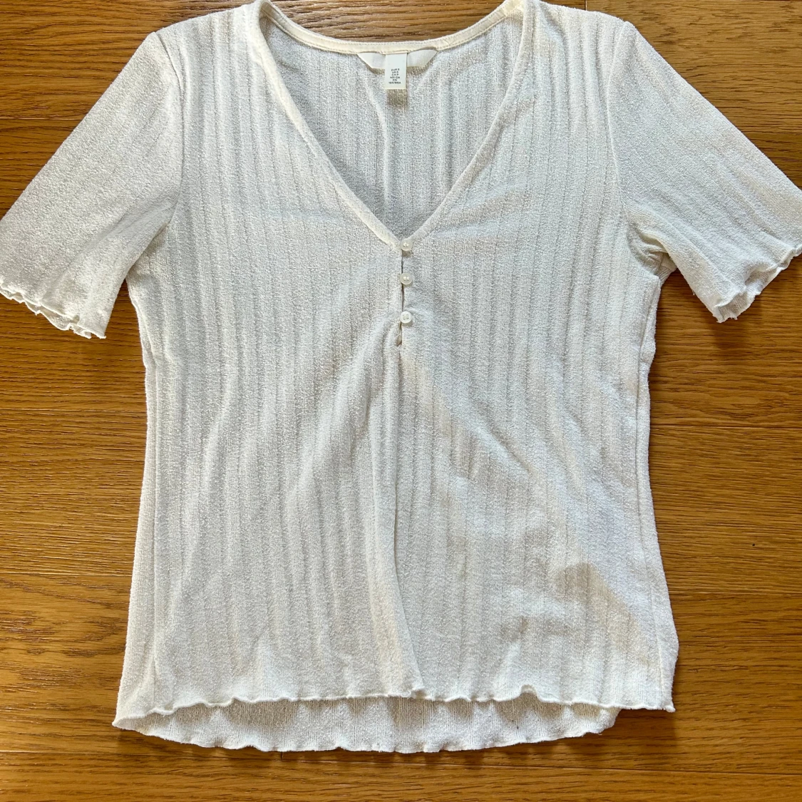 Vit ribbad topp med knappar från H&M