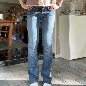 Lågmidjade utsvängda jeans  - Snyggaste jeansen!! De är vintage men i fint skick, har slitningar men ingår i modellen.  Innerben: 82 cm, midja rakt över: 37 cm Jättebekväma och stretchiga så passar nog Xs-s Kom privat för fler mått eller frågor🥰🥰