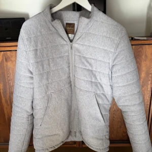 Ljusgrå quiltad jacka från Stenströms - hej! säljer denna snygga ljusgrå jacka från Stenströms med dragkedja framtill och två  fickor. Jackan har en stilren look med raka linjer och är tillverkad i mjukt bomullsmaterial. skriv vid frågor och funderingar 