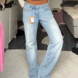 Weekday Arrow Low Straight Jeans 28/32 - Säljer ett par ljusblå Arrow Low Straight Jeans från Weekday i storlek 28/32. Jeansen har låg midja, raka ben och klassisk femficksdesign. Tillverkade i bomull med en snygg tvättad finish som ger en chill vibe.