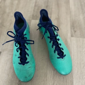 Adidas X Fotbollsskor – Blågrön i utmärkt skick! - Färgstarka Adidas X fotbollsskor i blågrönt med mörkblå detaljer. Rund tå, dobbar och bra grepp – perfekta för planen!