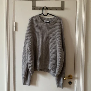 Grå stickad tröja från Weekday L - Oversized grå stickad tröja från Weekday i storlek L. Tröjan har en chunky ribbstickad struktur, rund halsringning och långa ärmar. 
