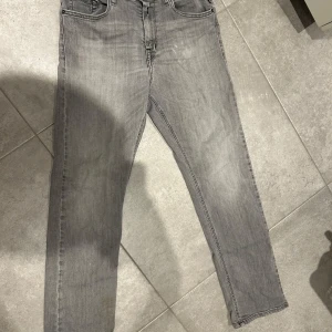 Grå jeansbyxor från Replay Thad - Snygga grå jeansbyxor från Replay, modell Thad. Klassisk femficksdesign med raka ben och svarta detaljer på bakfickorna. Jeansen är tillverkade i bomull och har en cool, tvättad look som passar perfekt till streetwear. Tar emot pris förslag!