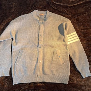 Grå kofta med vita ränder Fashion - Helt ny! Grå ribbstickad kofta från Fashion med knappar framtill och två fickor. Snygg detalj med tre vita ränder på ena ärmen. Rak passform och långärmad, perfekt för lager-på-lager. Enkel och stilren design som funkar till det mesta. Passar som M på mig som är 179 65kg. Dock står det XL på tagen men ni ser ju själva på bilden att den inte är det. Riktigt snygg om man har typ en hoodie under. Skriv vid minsta fråga😁😁