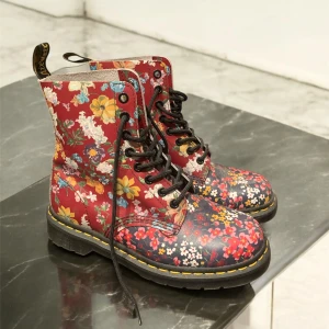 Original Sample Collection blommiga Dr. Martens boots strl 37 - Unika Dr. Martens boots i storlek 37 med färgglatt blommigt mönster på röd bas. Klassisk gul söm runt sulan, svarta snören och robust platt sula. Tillverkade i skinn och perfekta för dig som vill sticka ut med din stil. Orginala sample Dr. Martens 1460 PASCAL FLORAL CLASH. Bra for collectors och liknande.