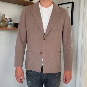 Beige stickad kavaj från John Henric - Snygg och skön kavaj ifrån John Henric perfekt inför hösten. Passar lika bra för formellt evenemang likaså till vardags. Inga defekter! 