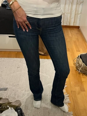 Mörkblå bootcut jeans från Zara - Säljer ett par mörkblå jeans från Zara i bootcut-modell. Jeansen har klassisk femficksdesign, normal passform. Mer en 34 än 32 och passar mig 34-36 i byxor!