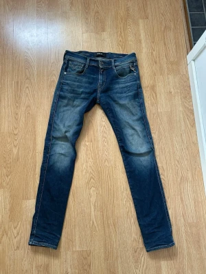 Replay Anbass Hyperflex jeans blå - Säljer ett par Replay Anbass Hyperflex jeans i klassisk blå tvätt. Har en liten slitning vid baksidan över högra fickan som knappt inte syns 