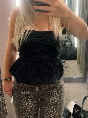 Svart peplum tubtopp - Snygg svart tubtopp med peplumvolang och rynkade detaljer framtill! 🖤