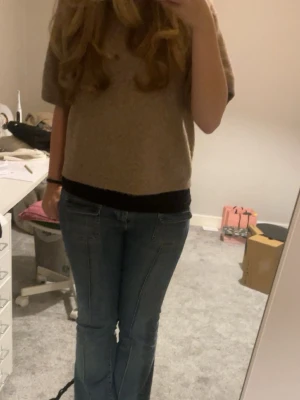 Blå bootcut jeans med rå kant - Säljer ett par blå jeans med bootcut-modell och rå, fransad kant längst ner. Jeansen har markerade sömmar framtill och klassiska fickor både fram och bak. Perfekta för dig som gillar en avslappnad och trendig look. De är uppklippta eftersom de va för långa och de har defekter på insidan av låren, men det är inget som syns. 