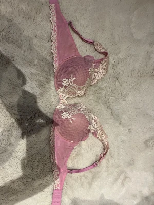 Intimissimi Rosa spets-bh, Pretty Flowers - *SÄLJS EJ LÄNGRE PÅ HEMSIDAN*- små tecken på användning vid brodering, vit tråd som sticker upp på nått ställe men inte mycket, går att klippa bort. -  Supersöt bh i ljusrosa med krämfärgad/vit spets och blommigt mönster - ur intimissimisPretty Flowers” kollektion. Axelbanden är justerbara och ryggen har klassisk hakknäppning. Perfekt för dig som gillar romantiska detaljer.  TVÄTTAS INNAN FÖRSÄLJNING💞