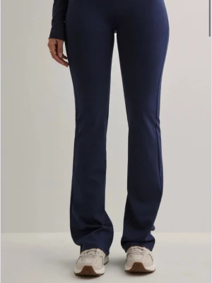 Mörkblå yogapants - Säljer ett par mörkblå träningsbyxor med bootcut passform från Nelly