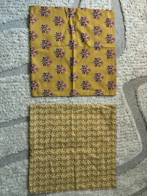 Blommiga gula kuddfodral från H&M Home - Säljer unika gula kuddfodral från H&M Home med dubbla blommiga mönster i lila och vitt. Ena sidan har större blommor, andra sidan mindre blommor i ett vågigt mönster. Kuddfodralen är i 100% bomull och har dragkedja. 50x50.