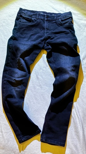 Svarta slim fit jeans LAB Industries - Svarta jeans från LAB Industries i modellen Luke/Slim Fit. Klassisk femficksdesign, dragkedja i gylfen och raka ben. Jeansen är tillverkade i ett stretchigt bomullsmaterial som sitter snyggt och bekvämt.