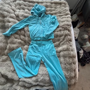 Turkos set Juicy Couture S - Säljer en turkos velourväst från Juicy Couture i storlek S. Västen har huva, dragkedja framtill och fickor. Klassisk logga broderad på bröstet och ribbade muddar. Perfekt för dig som gillar 00-talsstilen.