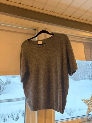 Grå stickad tröja från H&M - Mysig grå stickad tröja från H&M med rund halsringning och korta ärmar. Enkel och stilren design som funkar till det mesta. Aldrig använd men lappen är borttagen. Storlek L men köpte den större för den var liten i storleken, ville ha den lite mer loose. En M skulle jag säga.