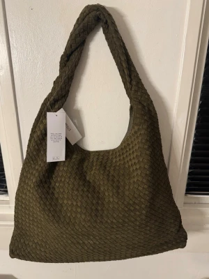 Flätad väska - Säljer en flätad väska från ginatricot som aldrig har använts, den har fortfarande påse och lappen kvar. Säljer då jag köpte två.