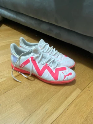  Puma futsalskor 42 - Säljer ett par vita Puma fotbollsskor med skön passform och snygga rosa detaljer. Skorna har snörning, perforerade partier för ventilation och en platt, rosa sula som passar perfekt för inomhusspel. Tillverkade i syntetmaterial för lätt känsla och bra grepp.den är helt ny om du ser något annat än att den är ny så kan du returnera den direkt. 