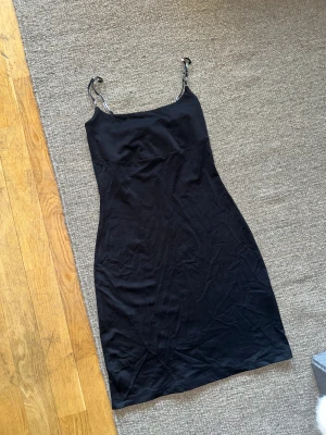 90’s klänning! - Svart miniklänning i 90’s stil med smala paljettklädda axelband som verkligen glittrar. Jag är 165 cm lång och den är perfekt längd på mig! Tjockt formande material. 