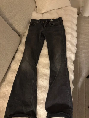 Svarta bootcut jeans från Levi's - Säljer ett par svarta lågmidjade Levi's jeans med bootcut passform och klassisk femficksdesign. Jeansen har låg midja och är tillverkade i mjukt denim med lätt tvättad look. Säljer då de tyvärr är för stora i midjan för mig och ser därför högmidjade ut även fast de är hyfsat låga