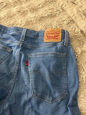 Levi's 517 ljusblå bootcut jeans - Säljer ett par klassiska Levi's 517 jeans i ljusblå tvätt med bootcut passform. Jeansen har fem fickor, Levi's patch och röd etikett bak. Tillverkade i mjukt jeanstyg med snygga sömmar och bälteshällor. Perfekt för dig som gillar retrovibe och avslappnad stil. Pris kan diskuteras 