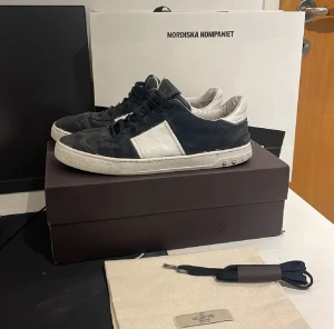 Valentino Garavani Rockrunner sneakers - Säljer ett par Valentino Garavani Rockrunner sneakers i svart och vitt med coola nitar på sulan. Skorna har snörning, platt sula och är tillverkade i mocka och skinn. Klassisk rund tå och lågt skaft. Medföljer extra svarta skosnören och dustbag. ÖPPEN FÖR BYTE!🙌🏻