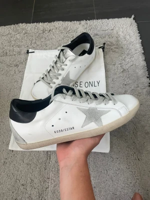 Golden Goose vita sneakers med stjärna - Jättesnygga Golden Goose i storlek 43! Super bra skick, de är knappast använda. Dustbag fås med, finns även kvitto/äkthetsbevis! Tveka inte på att höra av dig vid frågor eller intresse😊
