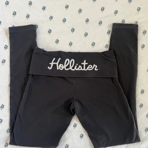 mörkgråa vintage foldover leggings Hollister XS - mörkgråa vintage foldover leggings från Hollister med bred midja och stor broderad logga bak. Tight passform och stretchigt material som känns mjukt mot huden. Perfekta för chill eller träning. Klassisk Hollister-vibe med liten logga fram på midjan.
